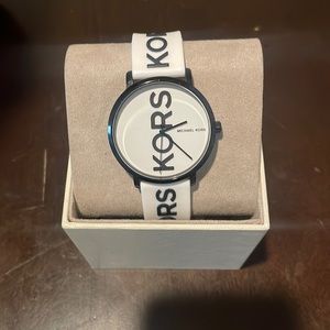 Unisex Michael Kors Watch. White silicone band with Kors printed in black.